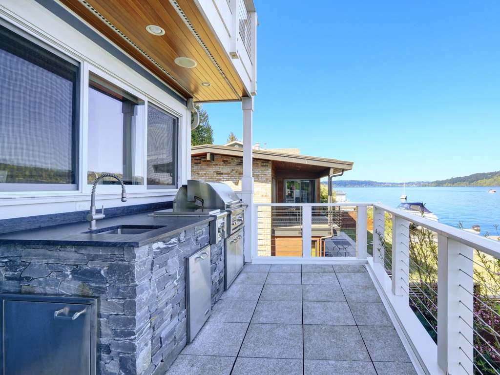House by the water with a built-in grill. Boulder Falls provides exceptional outdoor kitchen installations and built-in grills in Vancouver WA and Camas WA.
